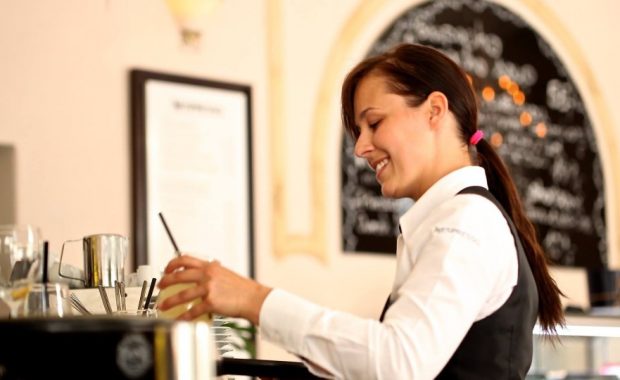 Waitress making a drink. Smiling. Happy. Engaged.