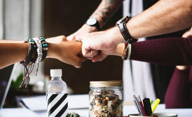 Employees giving each other a fist bump.