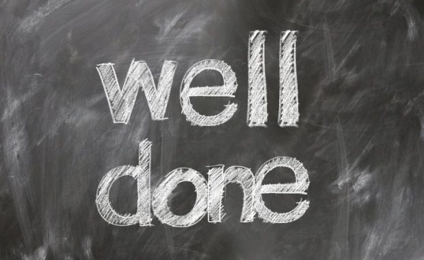 A chalkboard with the words "Well Done" written on it.