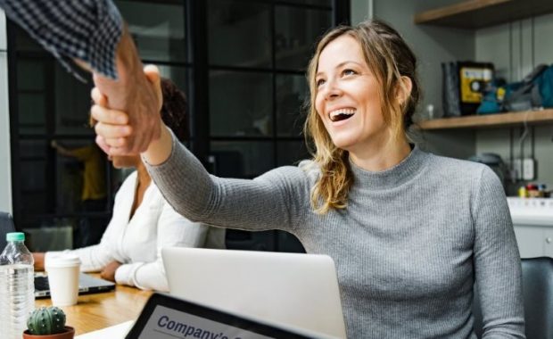 A woman shaking hands with a coworker