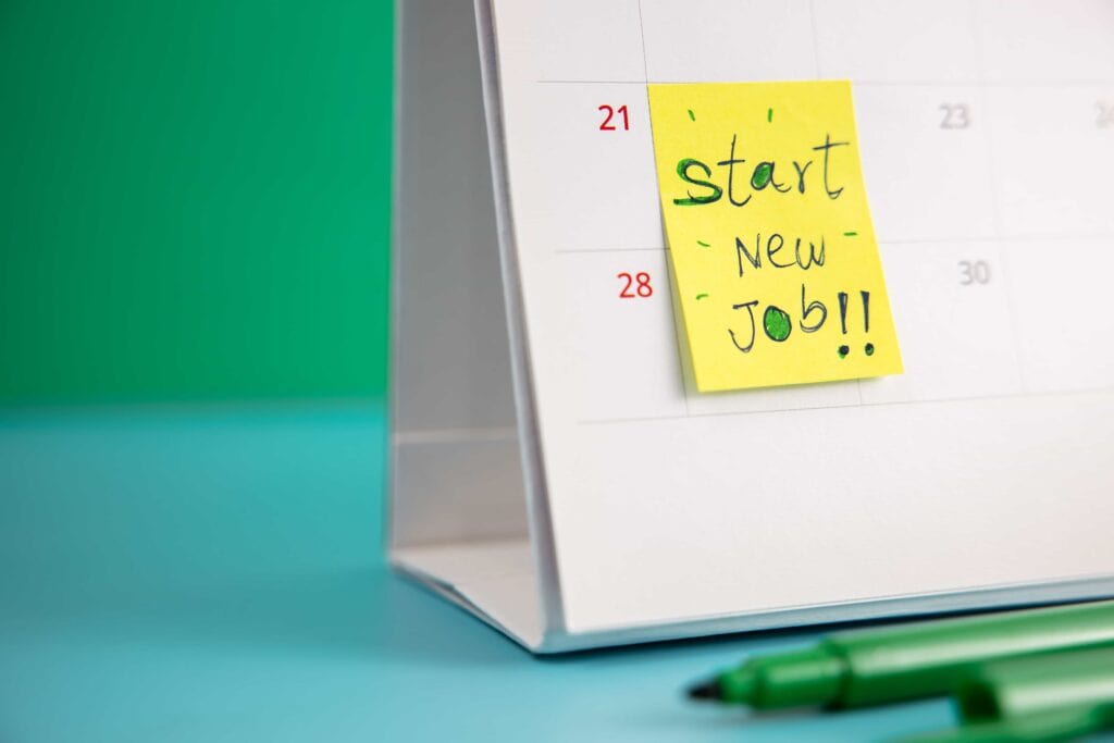 A yellow sticky note on a desktop calendar with the handwritten message 