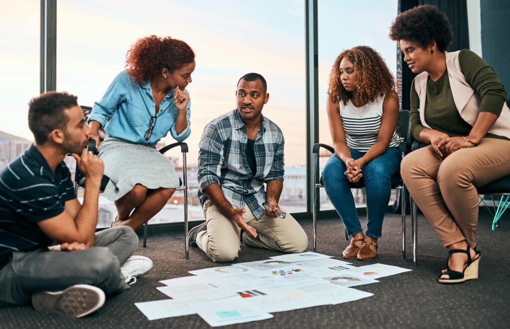 A diverse professional team brainstorming and reviewing strategy documents during a collaborative meeting in a bright office in Charlotte, NC.