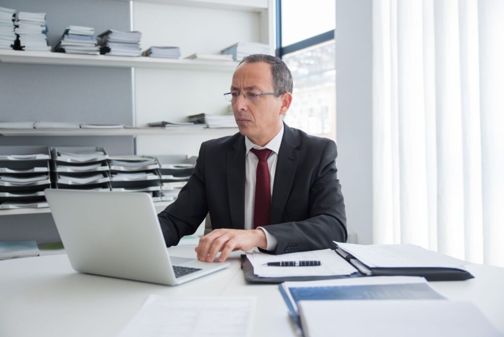 manager reviewing culture amp survey questions on a laptop in a hotel back office